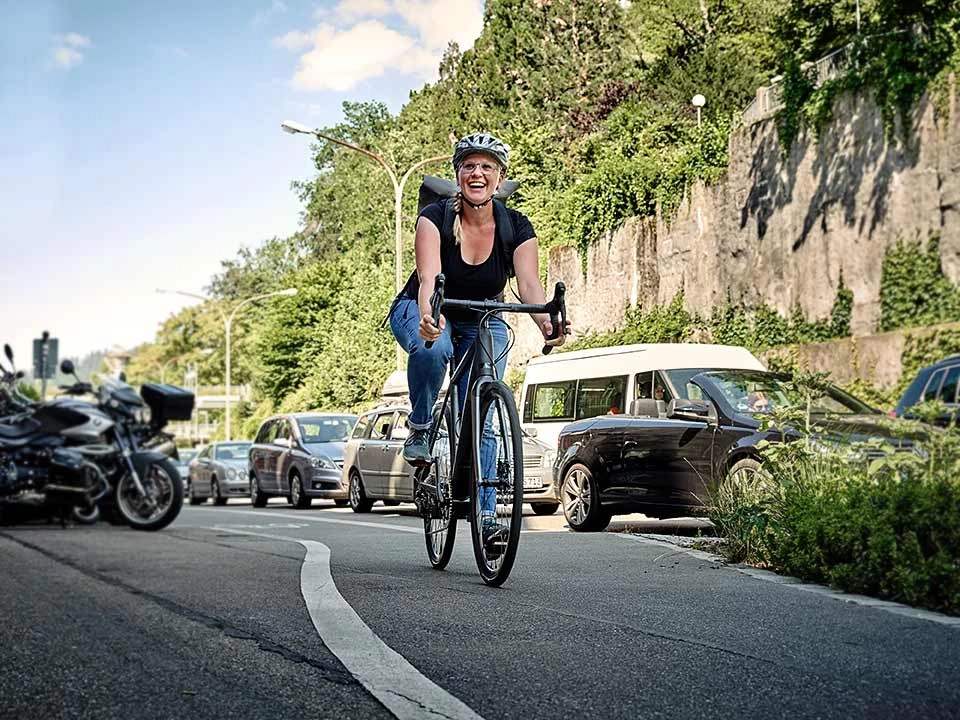 Frau fährt mit JobRad am Stau vorbei Frau fährt mit JobRad am Stau vorbei